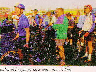 Riders in line for portable toilets at start line.